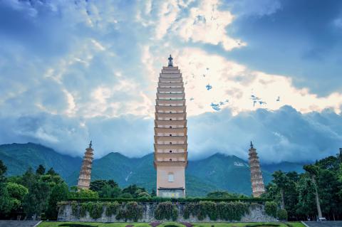 Iconic Three Pagodas of Chongsheng Temple at sunrise, Dali, Yunnan—a 1,000-year-old Buddhist landmark framed by Cangshan Mountain and Erhai Lake.