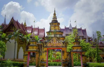 Palm-shaded paths and cultural monuments in Manting Park, a historic royal garden in Xishuangbanna, Yunnan, China.
