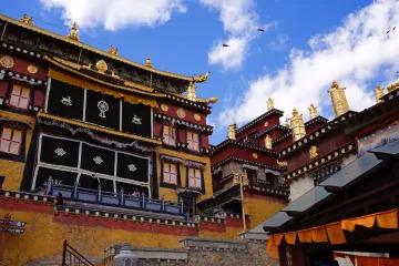 Golden rooftops and traditional Tibetan architecture of Songzanlin Monastery in Shangri-La, Yunnan—a spiritual landmark.