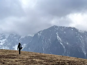 Hiker exploring the forested lower trails of Jade Dragon Snow Mountain, an epic outdoor adventure in Lijiang, China.